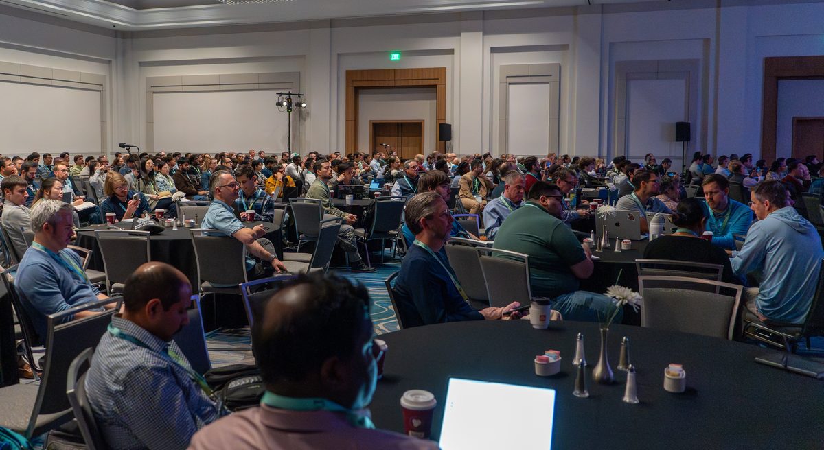 A packed general session, tables full across the ballroom