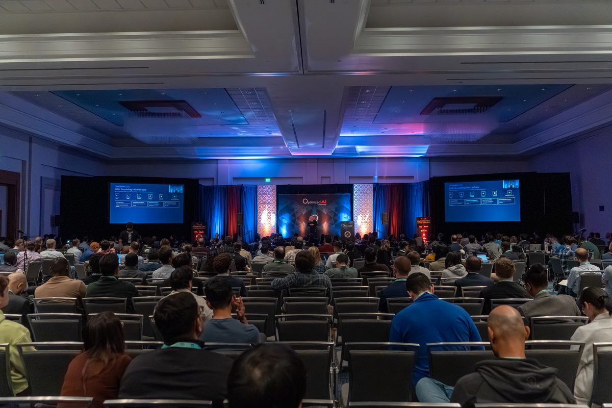 Attendees seated facing the main stage as a talk gets underway